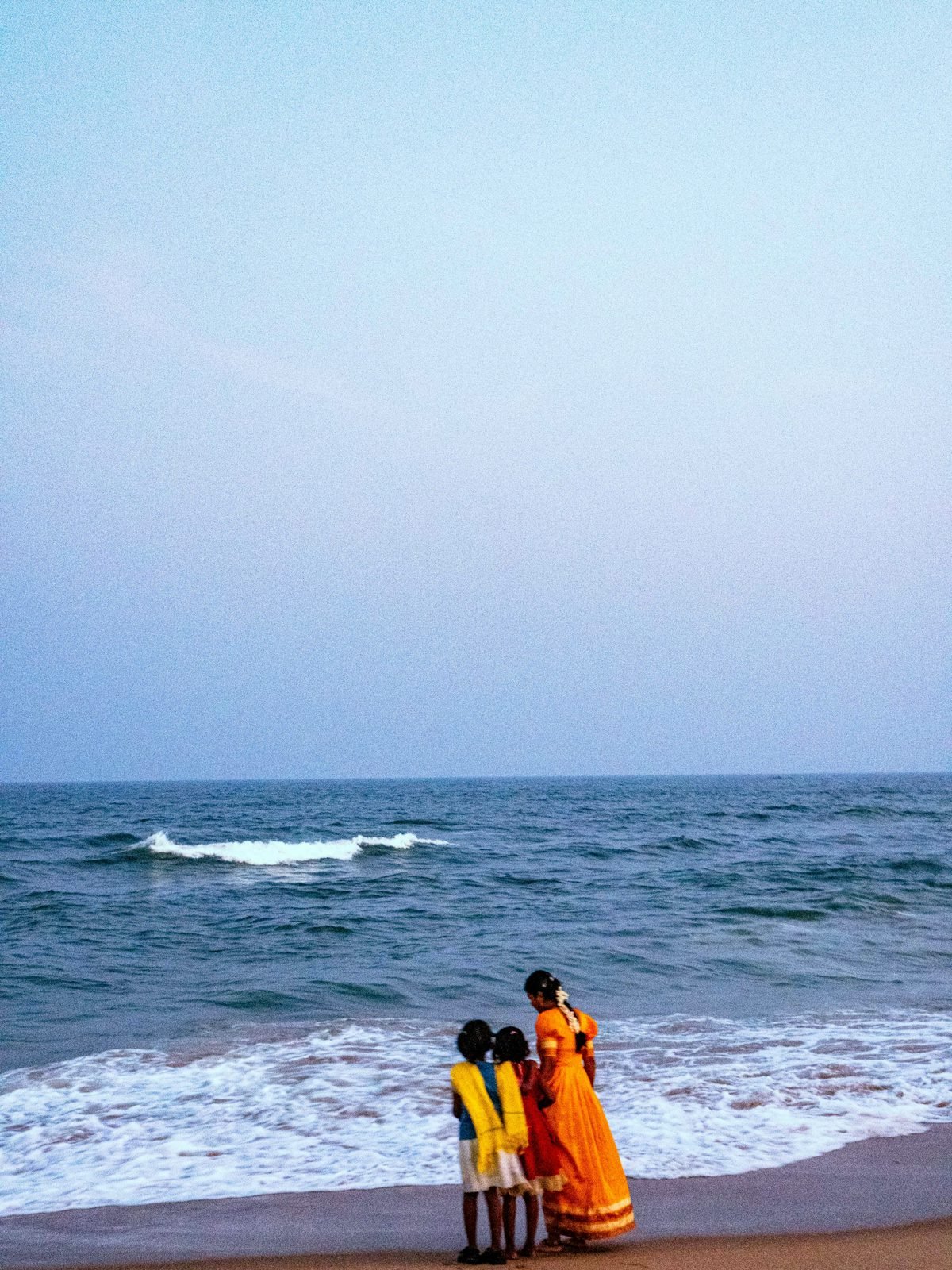 Family watching the waves together on a beach