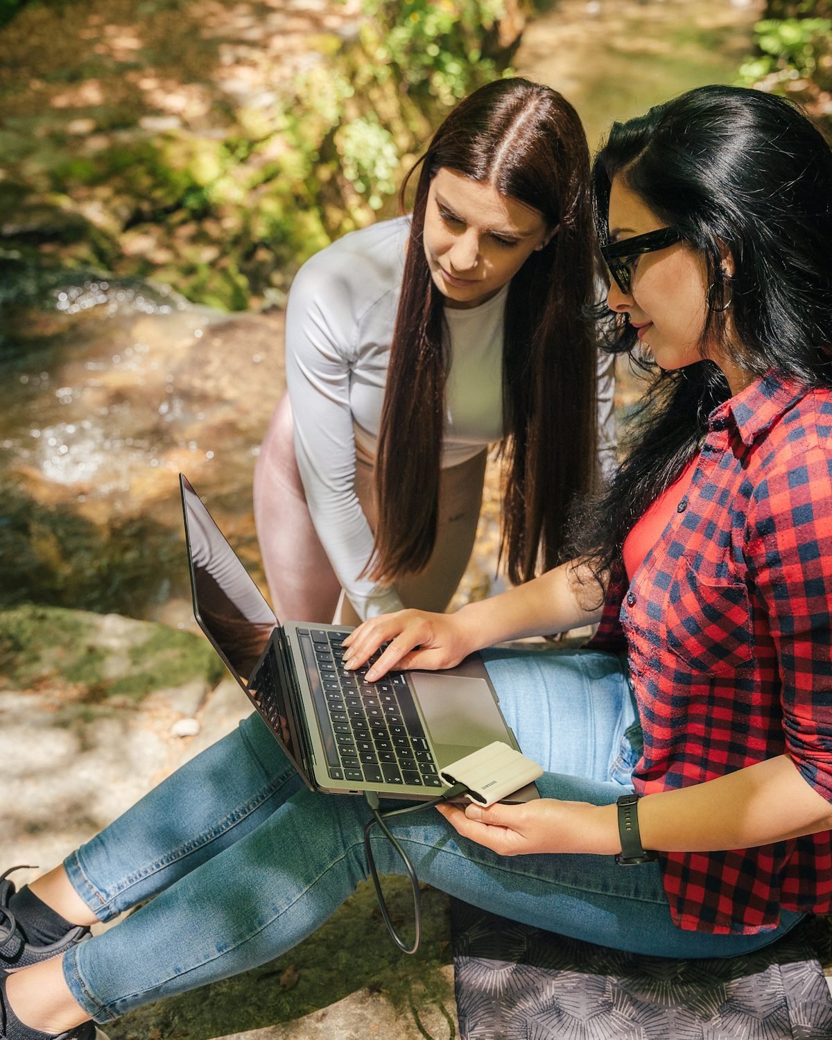 Two friends planning a trip together on a laptop